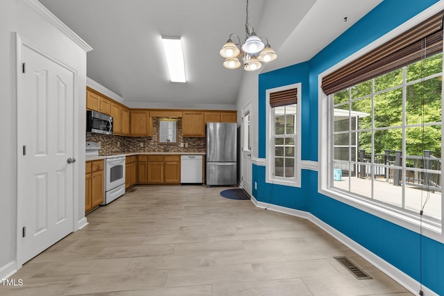 1383 Deercroft Ct, Graham, NC 27253 - kitchen with stainless steel appliances, vaulted ceiling, a sink, a chandelier, and decorative light fixtures