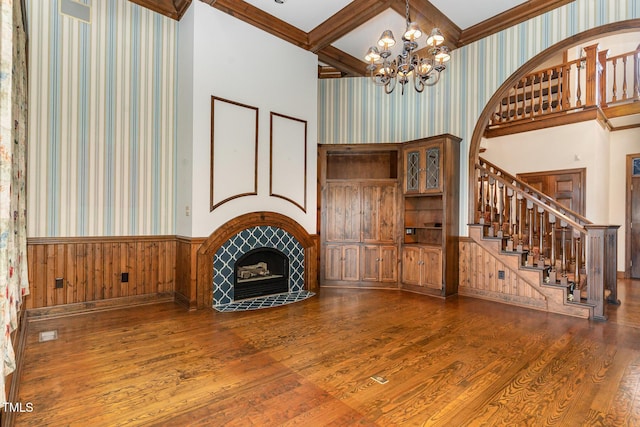 610 Walnut Creek Dr, Goldsboro, NC 27534 - unfurnished living room featuring wallpapered walls, a wainscoted wall, wood-type flooring, a chandelier, and stairway