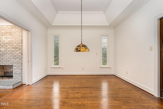 610 Walnut Creek Dr, Goldsboro, NC 27534 - unfurnished dining area featuring a raised ceiling, wood finished floors, ornamental molding, a brick fireplace, and baseboards