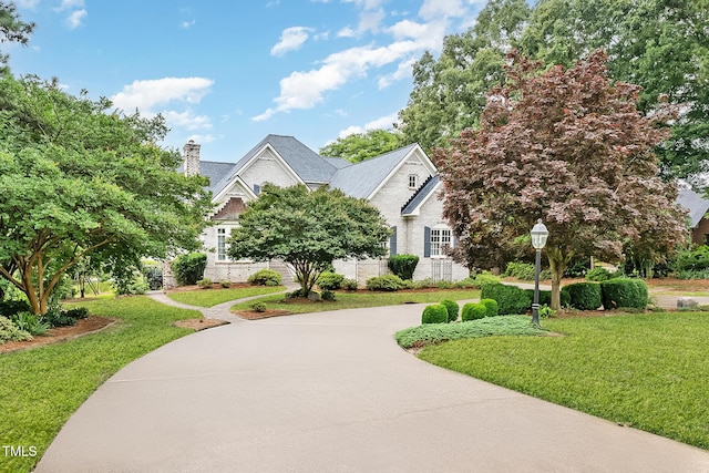 610 Walnut Creek Dr, Goldsboro, NC 27534 - view of front facade featuring a front yard, brick siding, a chimney, and concrete driveway