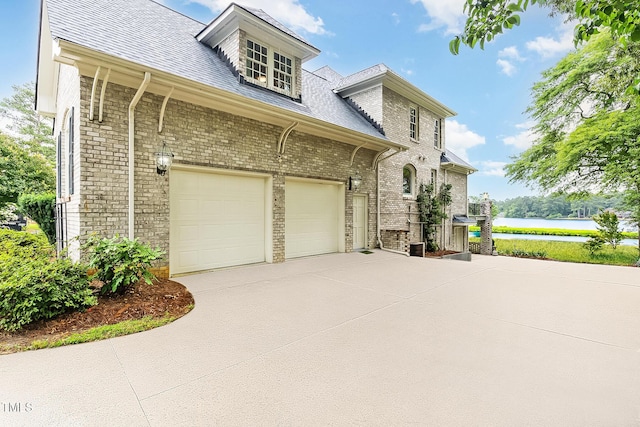 610 Walnut Creek Dr, Goldsboro, NC 27534 - view of side of property with concrete driveway, brick siding, a water view, and roof with shingles