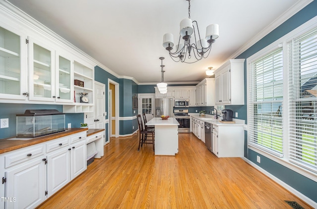 104 Goldleaf Ct, Angier, NC 27501 - kitchen with stainless steel appliances, baseboards, a sink, a chandelier, and white cabinets