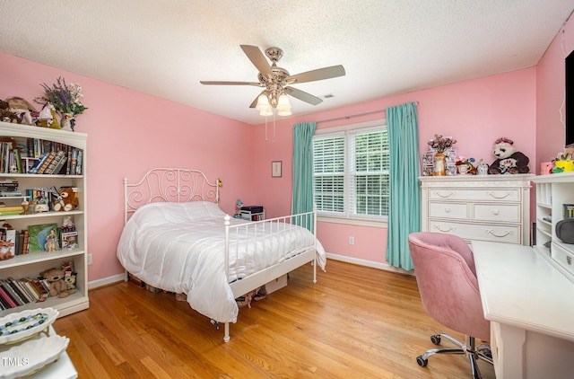 104 Goldleaf Ct, Angier, NC 27501 - bedroom with light wood-type flooring, baseboards, a textured ceiling, and a ceiling fan