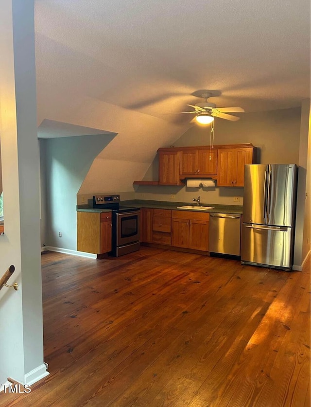 300 Christmas Rd, Warrenton, NC 27589 - kitchen featuring appliances with stainless steel finishes, brown cabinetry, dark wood-style flooring, a ceiling fan, and lofted ceiling