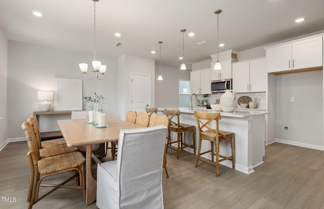 1525 Tamarisk Ln, Durham, NC 27703 - dining space featuring light wood-type flooring, a chandelier, baseboards, and recessed lighting