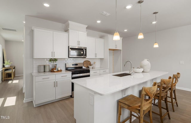 1525 Tamarisk Ln, Durham, NC 27703 - kitchen with stainless steel appliances, a sink, decorative backsplash, light wood-style flooring, and recessed lighting