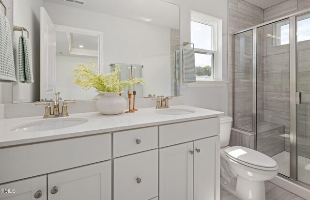 1525 Tamarisk Ln, Durham, NC 27703 - bathroom featuring toilet, double vanity, and a stall shower