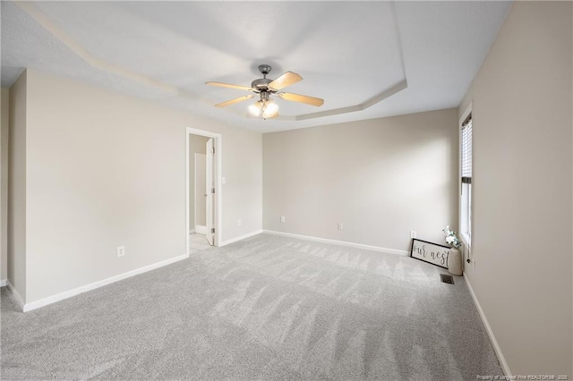 5511 Shady Lawn Dr, Hope Mills, NC 28348 - spare room with ceiling fan, a tray ceiling, baseboards, and carpet