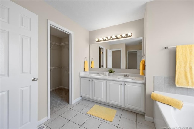 5511 Shady Lawn Dr, Hope Mills, NC 28348 - full bathroom with double vanity, a tub, baseboards, tile patterned flooring, and a spacious closet