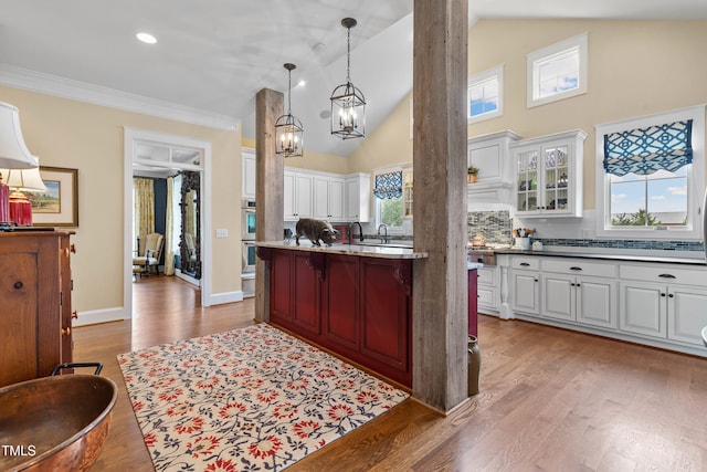 4737 Uzzle Rd, Rougemont, NC 27572 - kitchen featuring a chandelier, white cabinetry, glass insert cabinets, wood finished floors, and a kitchen breakfast bar