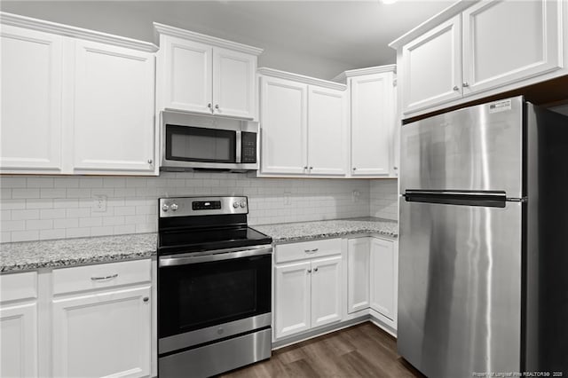 4616 Scenic Pines Dr, Hope Mills, NC 28348 - kitchen with appliances with stainless steel finishes, white cabinetry, backsplash, dark wood finished floors, and light stone counters