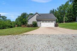 311 Rassie Crabtree Rd, Rougemont, NC 27572 - view of side of property with concrete driveway, a lawn, and a garage