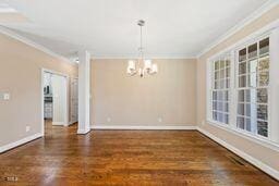 311 Rassie Crabtree Rd, Rougemont, NC 27572 - unfurnished dining area featuring crown molding, a chandelier, and wood finished floors