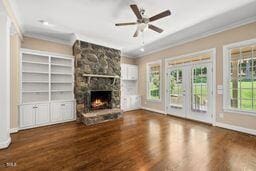 311 Rassie Crabtree Rd, Rougemont, NC 27572 - unfurnished living room featuring crown molding, a stone fireplace, wood finished floors, and french doors