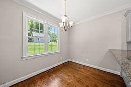 311 Rassie Crabtree Rd, Rougemont, NC 27572 - unfurnished dining area featuring a chandelier, crown molding, and wood finished floors