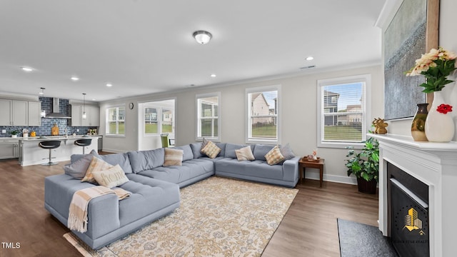 3421 Lebrun Path, Fuquay Varina, NC 27526 - living room with crown molding, healthy amount of natural light, recessed lighting, wood finished floors, and a fireplace with flush hearth