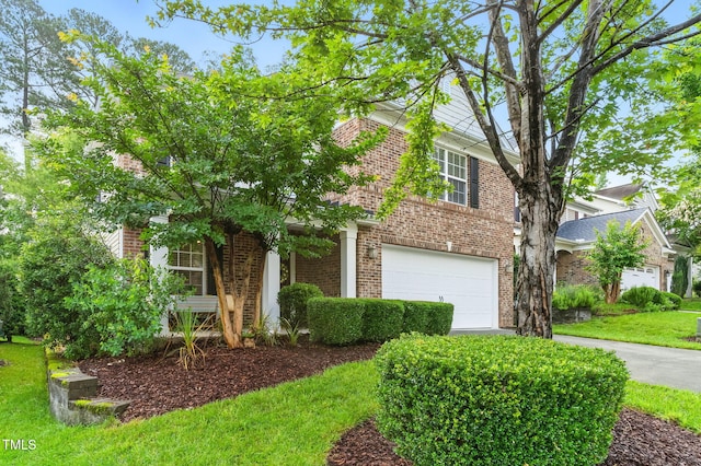 518 Emerald Downs Rd, Cary, NC 27519 - view of property hidden behind natural elements featuring brick siding, a garage, a front lawn, and driveway
