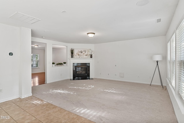 518 Emerald Downs Rd, Cary, NC 27519 - unfurnished living room featuring carpet floors, plenty of natural light, tile patterned flooring, and a tiled fireplace