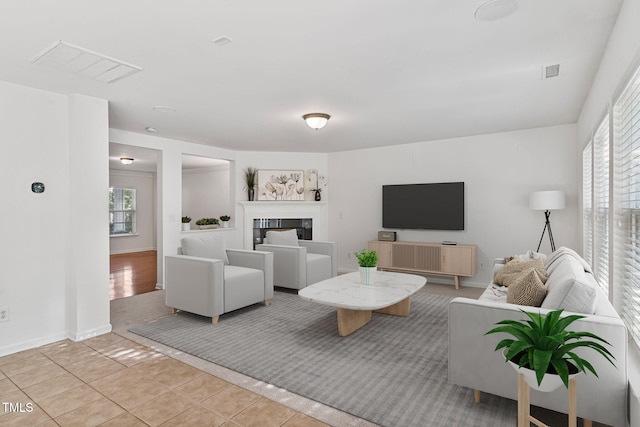 518 Emerald Downs Rd, Cary, NC 27519 - living area featuring healthy amount of natural light, light tile patterned floors, and a glass covered fireplace