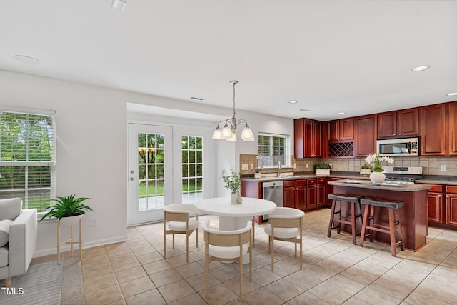518 Emerald Downs Rd, Cary, NC 27519 - kitchen featuring stainless steel appliances, decorative backsplash, dark brown cabinets, plenty of natural light, and recessed lighting