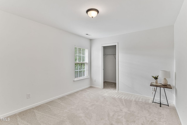 518 Emerald Downs Rd, Cary, NC 27519 - unfurnished bedroom featuring carpet flooring, a walk in closet, and a closet