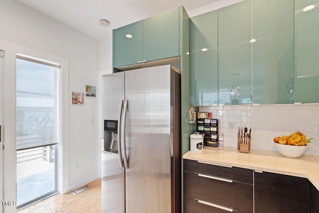 1314 S E St, Raleigh, NC 27601 - kitchen featuring stainless steel refrigerator with ice dispenser, decorative backsplash, light countertops, and modern cabinets