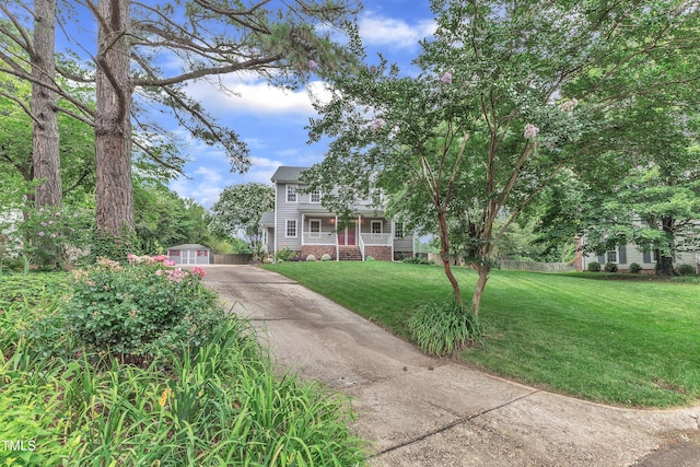 8121 Bentwood Pl, Raleigh, NC 27615 - view of front facade featuring covered porch, driveway, a front yard, and an outbuilding