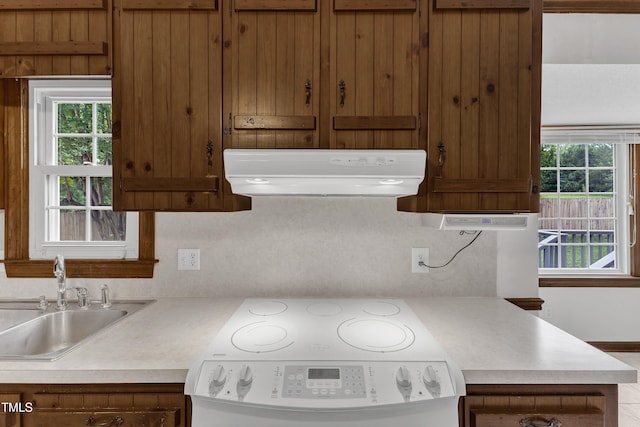 8121 Bentwood Pl, Raleigh, NC 27615 - kitchen with range hood, stove, a sink, and plenty of natural light