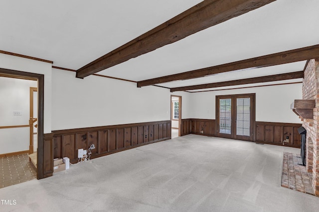 8121 Bentwood Pl, Raleigh, NC 27615 - unfurnished living room featuring a wainscoted wall, french doors, carpet, beam ceiling, and a fireplace