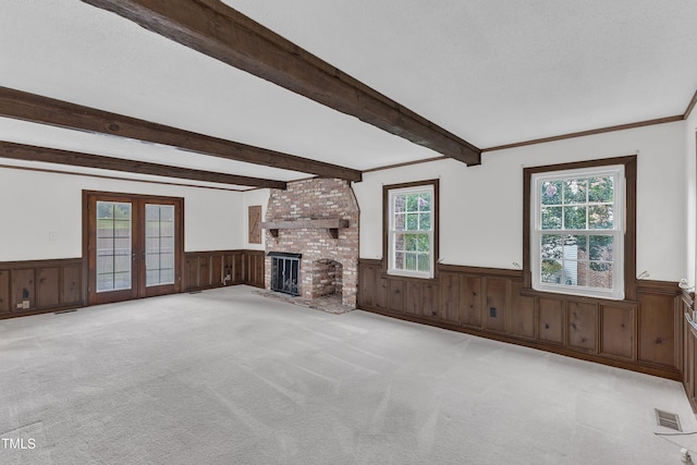 8121 Bentwood Pl, Raleigh, NC 27615 - unfurnished living room with a wainscoted wall, beam ceiling, french doors, carpet flooring, and a brick fireplace
