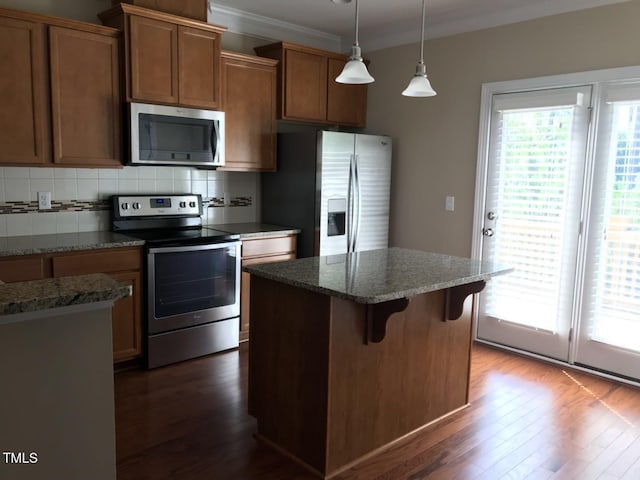 115 Ballyliffen Ln, Cary, NC 27519 - kitchen with stainless steel appliances, dark wood-style floors, a kitchen island, backsplash, and a kitchen bar