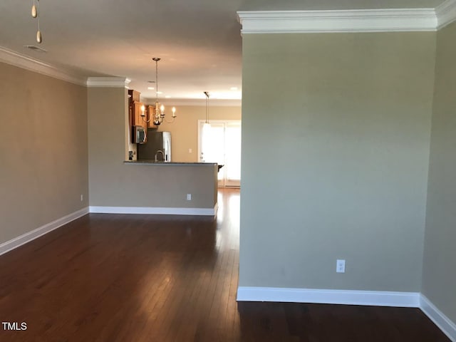 115 Ballyliffen Ln, Cary, NC 27519 - unfurnished living room with a chandelier, crown molding, dark wood-style flooring, baseboards, and a sink