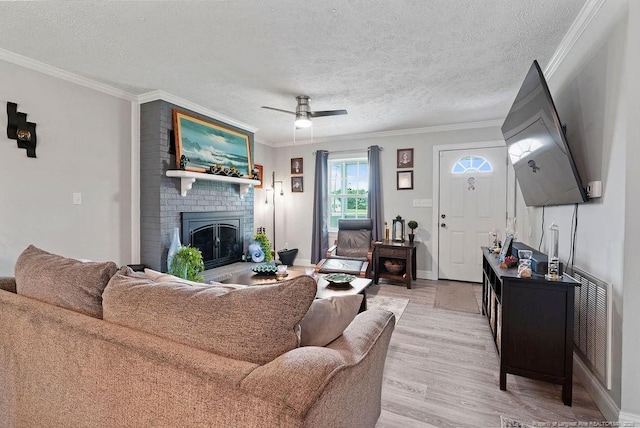 9872 NC-72 Hwy E, Lumberton, NC 28358 - living area with light wood-type flooring, crown molding, a fireplace, a textured ceiling, and a ceiling fan