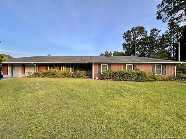 815 Whispering Pines Rd, Fayetteville, NC 28311 - ranch-style house featuring an attached garage, brick siding, a front yard, and driveway