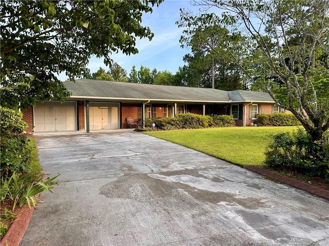 815 Whispering Pines Rd, Fayetteville, NC 28311 - ranch-style house with brick siding, an attached garage, a front yard, and concrete driveway