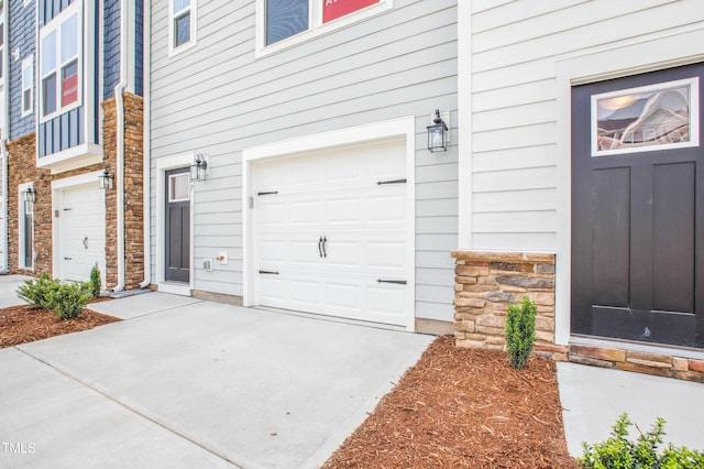 744 Parc Townes Dr Unit 34, Wendell, NC 27591 - view of exterior entry with stone siding, an attached garage, and driveway