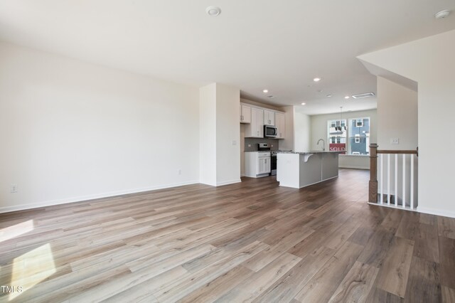 744 Parc Townes Dr Unit 34, Wendell, NC 27591 - unfurnished living room featuring a sink, wood finished floors, recessed lighting, and baseboards