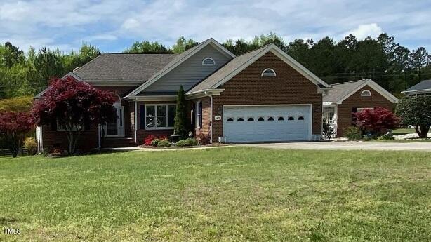 3409 Bennyfield Ct, Fuquay Varina, NC 27526 - view of front facade featuring a front lawn, an attached garage, and brick siding