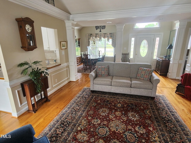3409 Bennyfield Ct, Fuquay Varina, NC 27526 - living room featuring ornate columns, light wood-type flooring, a decorative wall, a wainscoted wall, and crown molding