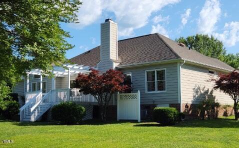 3409 Bennyfield Ct, Fuquay Varina, NC 27526 - rear view of house with a chimney, a lawn, a wooden deck, and stairs
