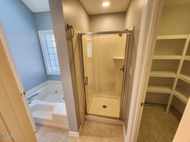 3409 Bennyfield Ct, Fuquay Varina, NC 27526 - bathroom featuring a bath, a shower stall, tile patterned floors, and a spacious closet