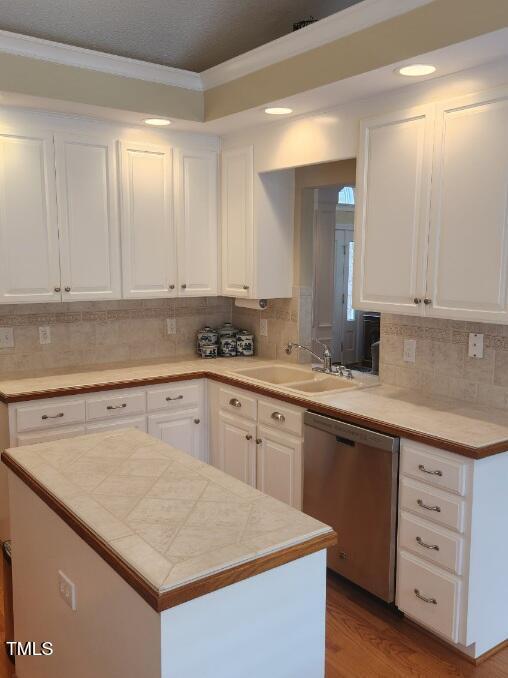 3409 Bennyfield Ct, Fuquay Varina, NC 27526 - kitchen with dishwasher, white cabinetry, decorative backsplash, ornamental molding, and light countertops