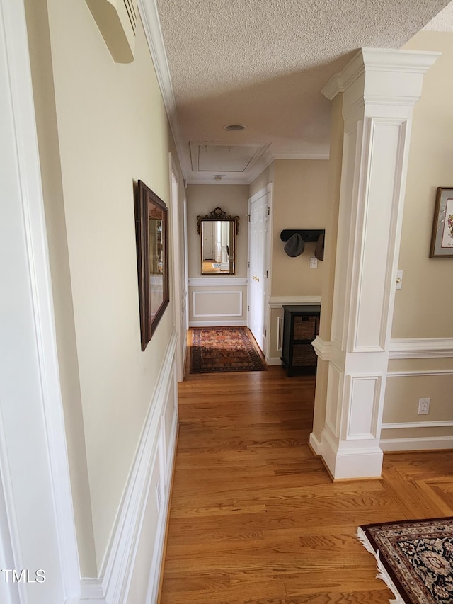 3409 Bennyfield Ct, Fuquay Varina, NC 27526 - corridor with a textured ceiling, attic access, ornamental molding, light wood-type flooring, and decorative columns