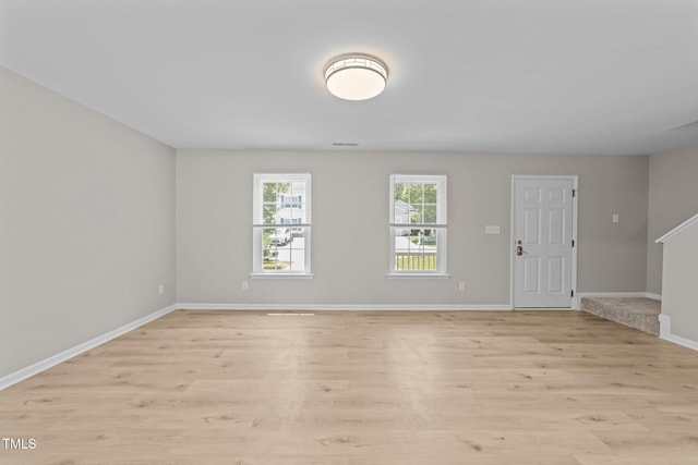 5012 Silverdene St, Raleigh, NC 27616 - unfurnished living room with light wood-type flooring, baseboards, and stairs