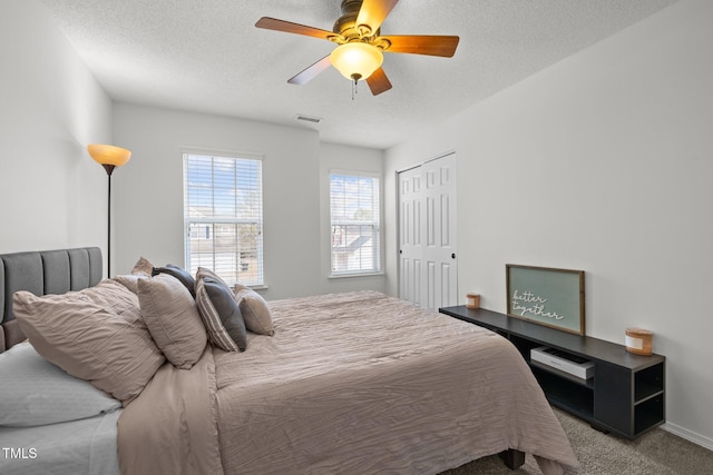 5332 Seaspray Ln, Raleigh, NC 27610 - carpeted bedroom featuring a textured ceiling, a ceiling fan, a closet, and baseboards