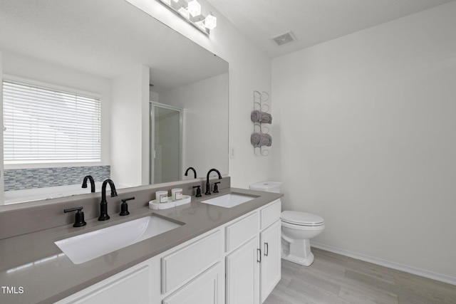 5332 Seaspray Ln, Raleigh, NC 27610 - bathroom with toilet, wood finished floors, double vanity, a stall shower, and baseboards