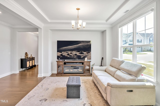121 Canyon Gap Way, Raleigh, NC 27610 - living room with a chandelier, plenty of natural light, wood finished floors, a raised ceiling, and ornamental molding