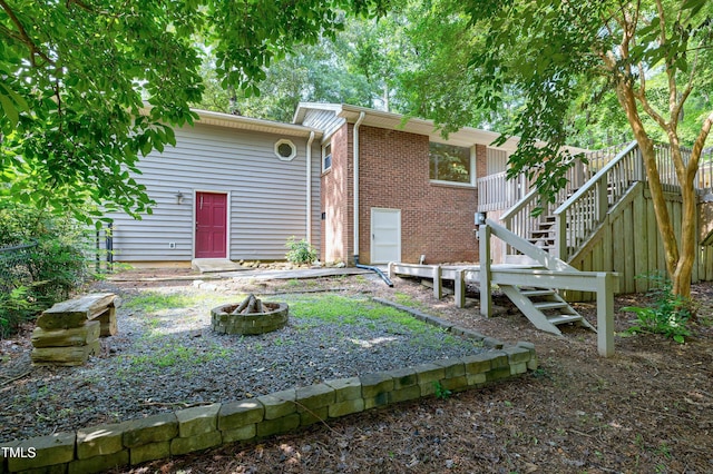 1416 Bramble Dr, Durham, NC 27712 - rear view of house featuring an outdoor fire pit, stairway, and brick siding
