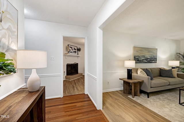 1416 Bramble Dr, Durham, NC 27712 - living area with wood finished floors, a fireplace with raised hearth, and baseboards