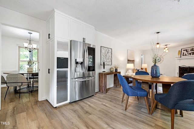 1416 Bramble Dr, Durham, NC 27712 - kitchen featuring stainless steel refrigerator with ice dispenser, a chandelier, light wood finished floors, white cabinetry, and a textured ceiling